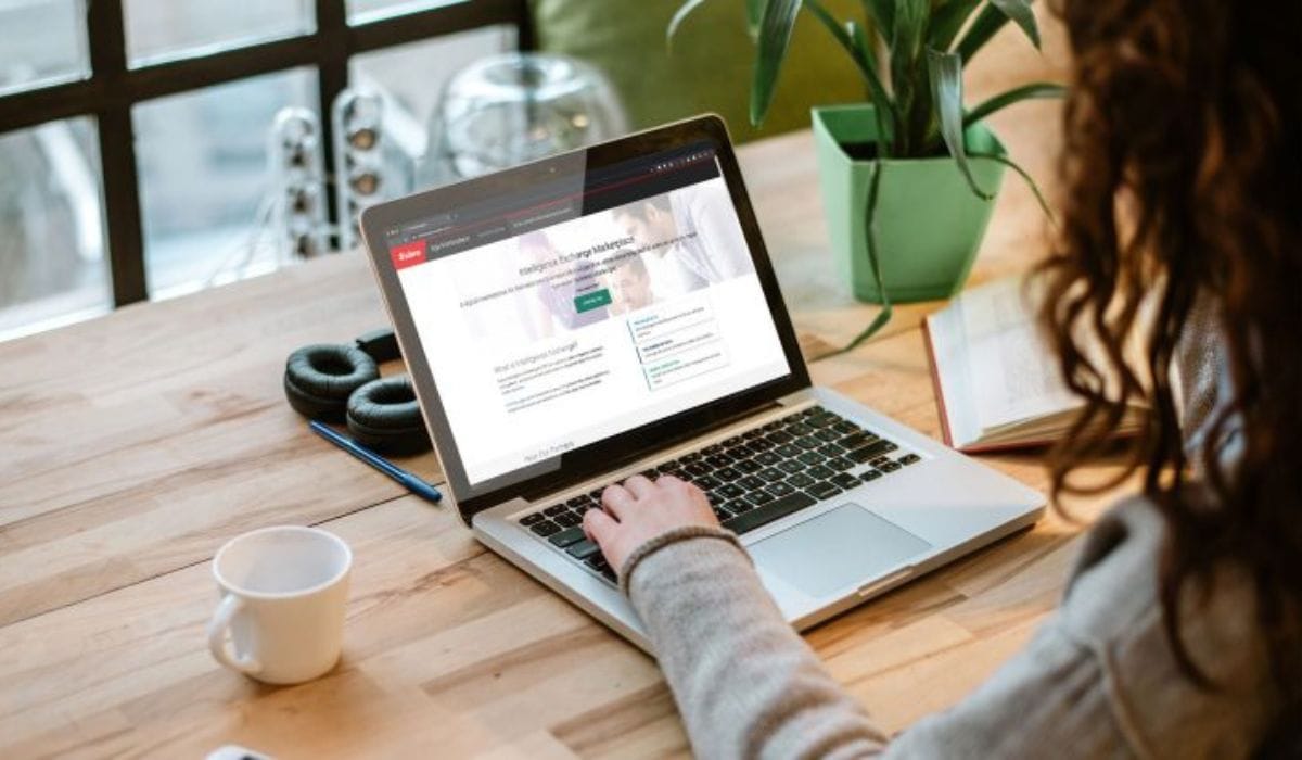 An over-the-shoulder view of a person using a laptop to access the Sabre Intelligence Exchange Marketplace, representing Sabre Corporation's transition toward an AI-native and cloud-based technology infrastructure.